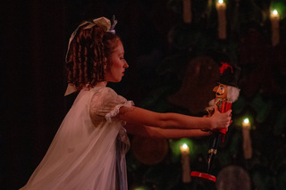 After everyone goes to bed, Clara dances around the living room with her nutcracker. Only the light from the Christmas tree illuminated Clara and her beloved present from her godfather. 