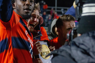 Julius Rauch holds the NCAA trophy with an ear-to-ear smile on his face, flanked by Olu Oyegunle. Every player on the team was emotional as the national title was announced to them. 