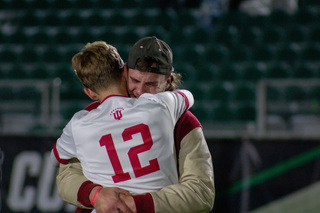Indiana fans take to the field to comfort their team after the loss to the Orange. Quinten Helmer, a junior midfielder for the Hoosiers, embraced his friend amid the chaos of the win on the other side of the field.