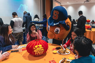 A variety of Chinese dishes and foods were offered at the event for students to try. Students sat eating their food as Otto the Orange made an appearance at the event and joined their table.