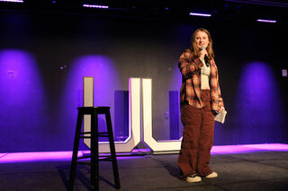Sarah Wells stands before the crowd telling jokes for the “College Chuckle” student comedy show. The event created a space for comedians of all years and experience levels to showcase their sets as well as bond with each other. 